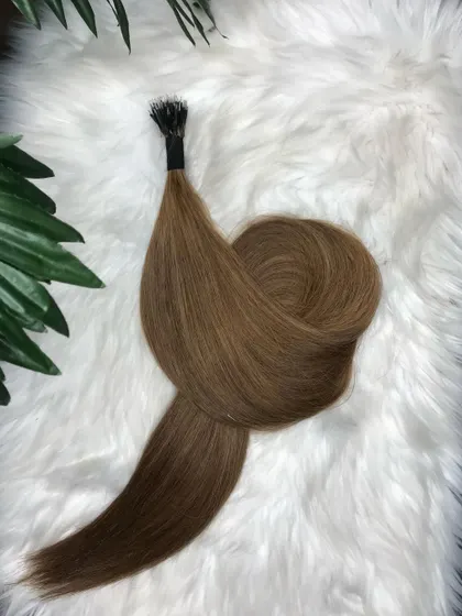 A beautifully arranged bundle of our light brown I-Tip extensions on a soft, white background, highlighting the product's silky texture and quality.
