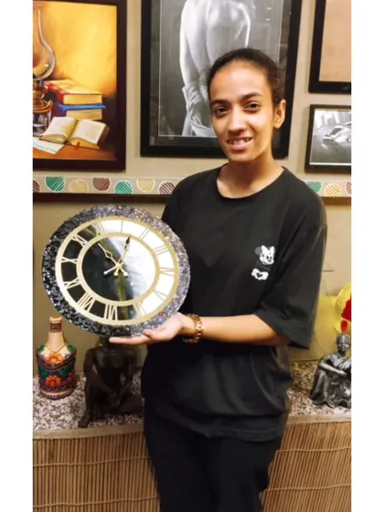 The final result: a student with her elegant black, white, and gold resin clock. A perfect example of the beautiful and functional art you can create with us.