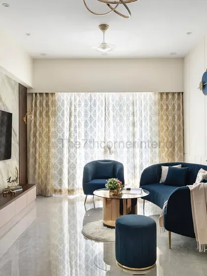 This wide shot of the 'Royal Mansion' living room captures the harmonious balance between the deep blue curved furniture, the book-matched marble TV wall, and the abundant natural light, creating a space of modern luxury.