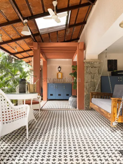 We created this beautiful outdoor space for our client's villa entrance. The patterned tiles, traditional swing, and bright blue shoe cabinet make for a warm and inviting welcome.