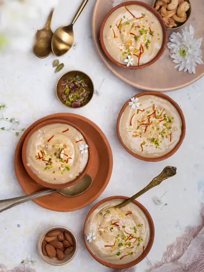 A festive spread of kheer for Janmashtami. The top-down angle showcases the beautiful styling with saffron and pistachios, served in traditional earthen pots for an authentic touch.