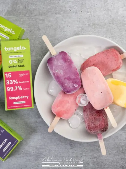 These colorful fruit sorbet sticks are presented simply to highlight their natural colors and refreshing quality. The shot communicates "healthy dessert" instantly.