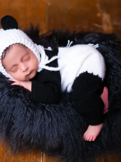 A close-up of the sleeping panda baby, showing the detail of the hand-knitted costume and the baby's peaceful expression. Safety and comfort are my top priorities in every pose.