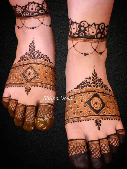 A modern and chic foot design with a bold band across the foot, featuring a rose in a diamond frame.