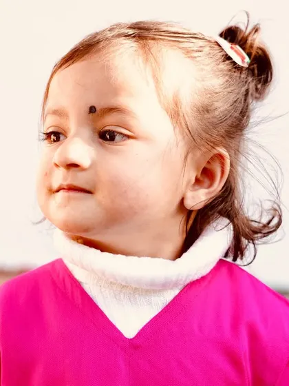 A sweet and innocent portrait of a young child. Capturing the natural curiosity of kids is always a joy, and this close-up shot in soft light makes for a beautiful memory.