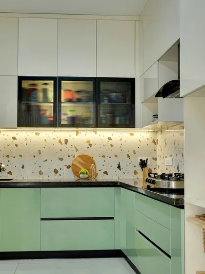 The kitchen combines white overhead cabinets with sage green base units, creating a light and airy feel.