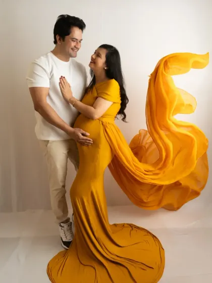 A bright and cheerful couple's portrait. The flowing yellow fabric adds a sense of movement and joy to the image.