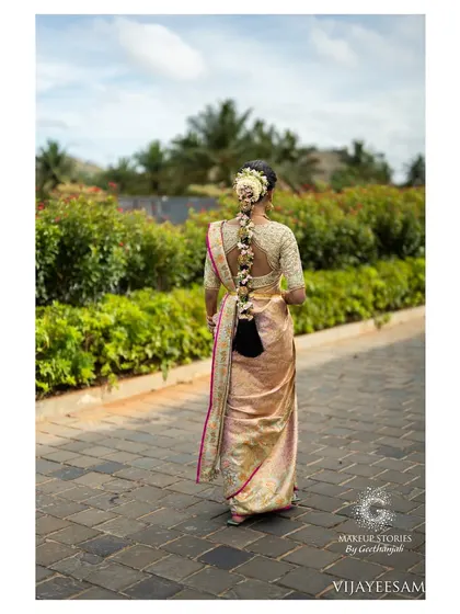 The back view of Ashitha's stunning bridal look. The long, traditional floral braid is a work of art and a key element of the classic South Indian bridal style.