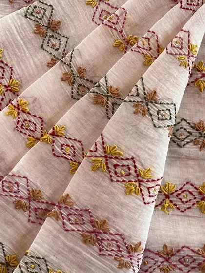 This hand-embroidered Mul Chanderi showcases a unique geometric pattern with colorful threads, offering a contemporary twist on traditional craftsmanship.