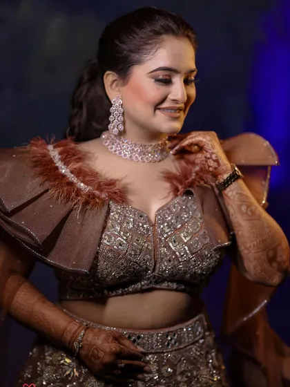 A radiant portrait of the bride on her engagement night, highlighting her beautiful makeup, jewelry, and the unique feathered details of her outfit.