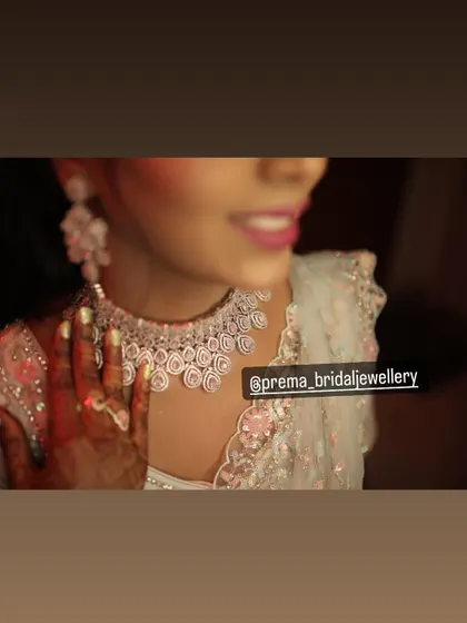 A close-up of a bride wearing a delicate pink stone and diamond-look choker.