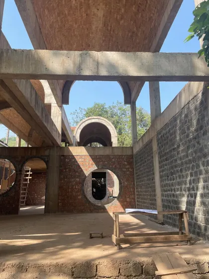 A moment on site at the House of Verses in Goa. The circular window frames a view through the structure, showcasing the geometric purity and material honesty of the brick and concrete before the final finishes are applied.