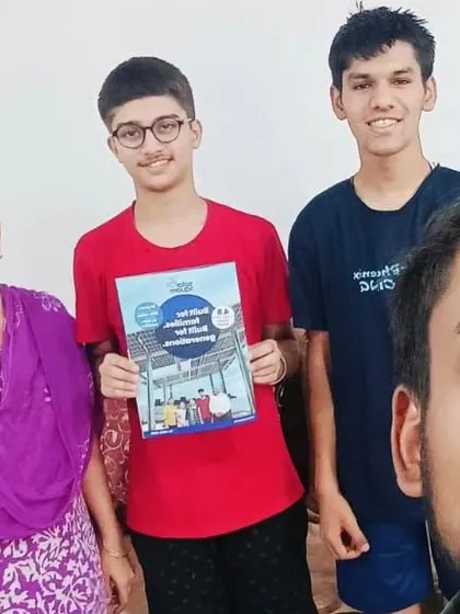 A family poses with our team member, holding our solar booklet. We believe in keeping our customers informed.