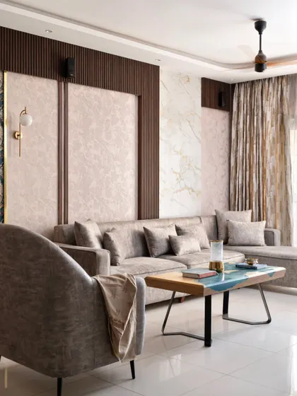 This living room from the 'Muditā' project showcases an elegant palette of wood, beige, and cream. I used vertical flutes and framed wallpaper panels to add texture and sophistication to the space.
