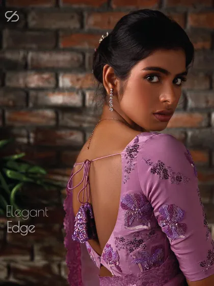 An elegant edge. The back of this lavender saree blouse features a deep cut and delicate floral appliqué, showcasing a modern and alluring design.