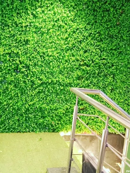 A simple but effective way to brighten up a staircase area. A clean, dense artificial green wall adds life and color to an otherwise plain part of the building.