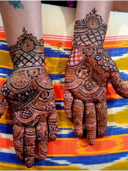 A modern take on festive henna, with geometric patterns on the wrist and a mix of circular motifs on the palm. It's a chic and stylish option.