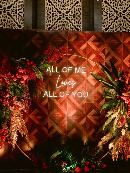 A neon sign with the words "All of me loves all of you" served as a perfect photo-op at this enchanted forest Sangeet.
