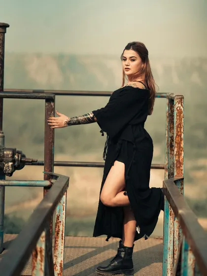 We found this rusty industrial platform overlooking a valley. The contrast between the decaying structure and the model's powerful pose is what makes this shot so compelling.