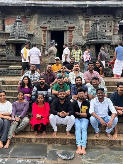 A group of trekkers posing on the steps of a historic temple during their weekend trip.