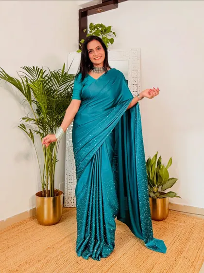 This teal satin saree with stonework is a beautiful party-wear option. The color is gorgeous and the subtle sparkle makes it perfect for evening events.