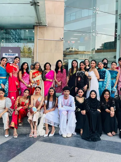 The entire team of student designers, models, and faculty pose for a group photo after a successful fashion show at Reliance Mall.