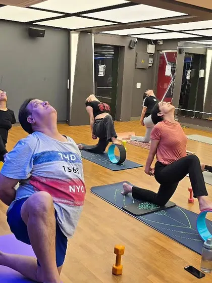 In my studio classes, we often use props like the yoga wheel to explore poses more deeply and safely. Here, my students are in a heart opening backbend, using the wheel to support their spine, enhance flexibility, and build core strength.