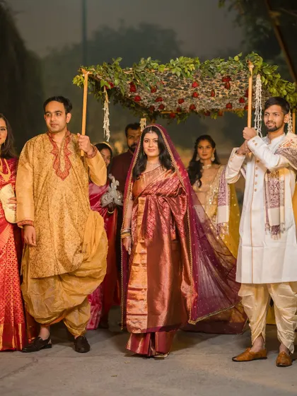 The bride's grand entrance under a 'phoolon ki chadar' held by her brothers. A powerful and traditional moment from her wedding day.
