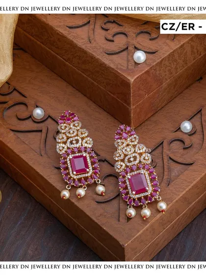 These statement earrings with large ruby stones and CZ accents are perfect for making a bold statement. They are glamorous and eye-catching.