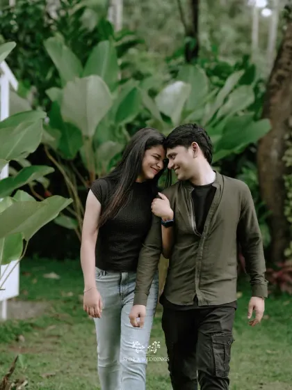 A happy, candid shot of the couple walking and laughing together in a beautiful garden.