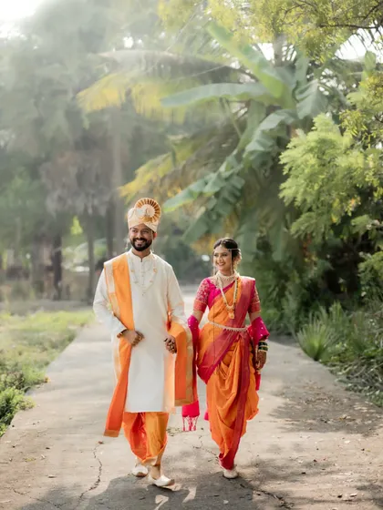A beautiful shot of the newly married couple walking down a path in a rustic setting, hand-in-hand.