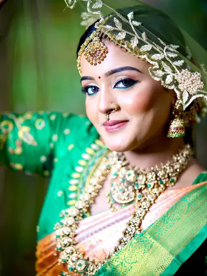 A close-up of this beautiful bride's look, showing the detail in her green embroidered blouse and the way it complements her silk saree.