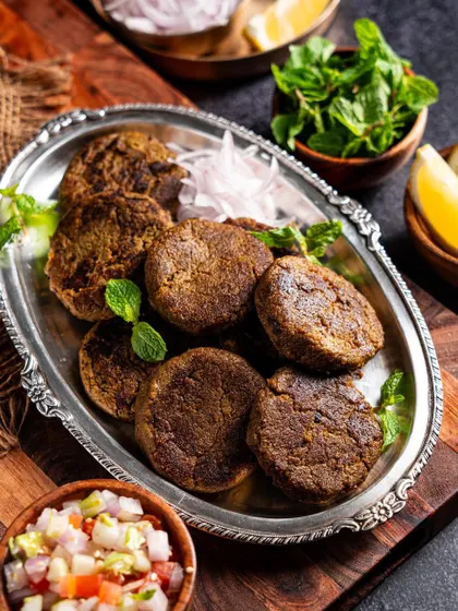 A platter of Hara Bhara Kebabs, styled with fresh garnishes. The composition is balanced and visually appealing for menu use.