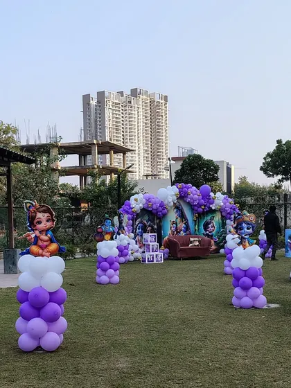 A wide shot of the park area decorated for the Krishna-themed event, with balloon pillars guiding the way.