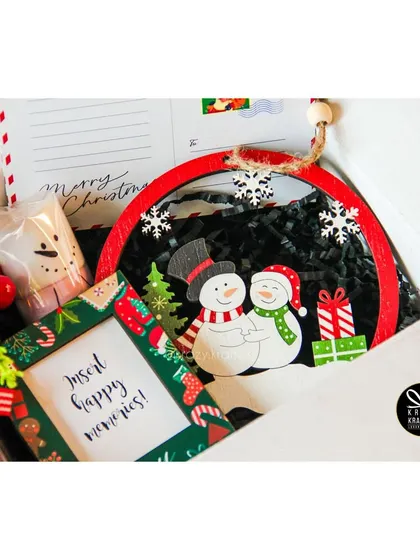 The 'Holly Jolly' budget-friendly Christmas hamper, featuring a snowman ornament and a reindeer nutty jar.