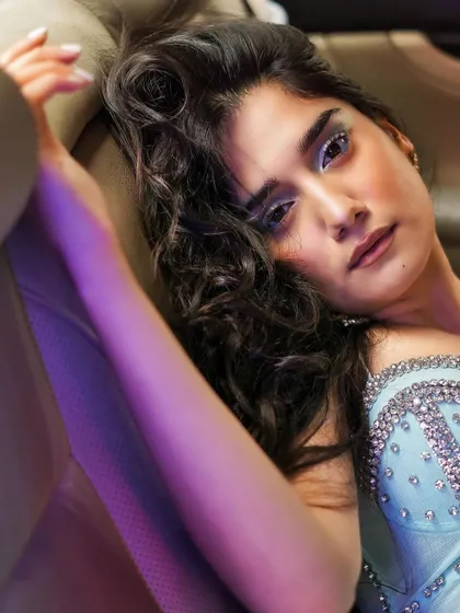 A dreamy, artistic close-up. The combination of icy blue makeup, a crystal-studded top, and soft purple lighting creates an ethereal and magical portrait.