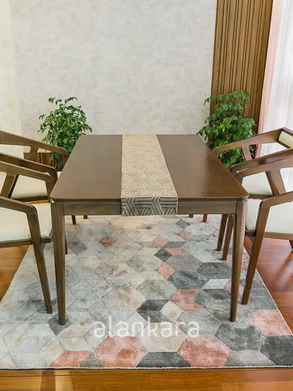 The Zircon dining set, crafted from rich teak wood and upholstered with premium fabric. The geometric design of the chairs and the clean lines of the table create a modern yet timeless look.
