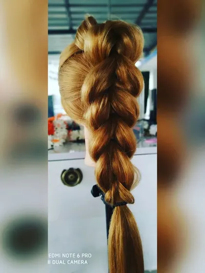 A clear shot of a thick and voluminous pull-through braid. This technique creates the illusion of fuller hair and is a popular choice for sangeet or mehendi functions.