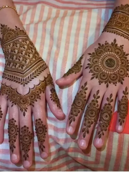 Two different styles of guest mehndi. One hand features a geometric pattern, while the other has a classic circular mandala, showing the variety I can offer.