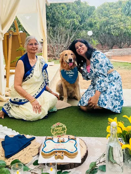 A beautiful photo of three generations of a family celebrating their dog's birthday. This image perfectly captures our belief that dogs are cherished family members.