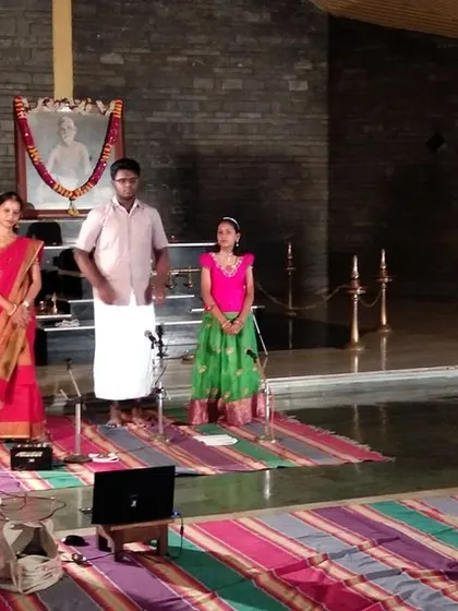 The student performers and their guru stand to receive blessings after their musical offering at the Pournami celebration. We emphasize respect for the guru and the art form.