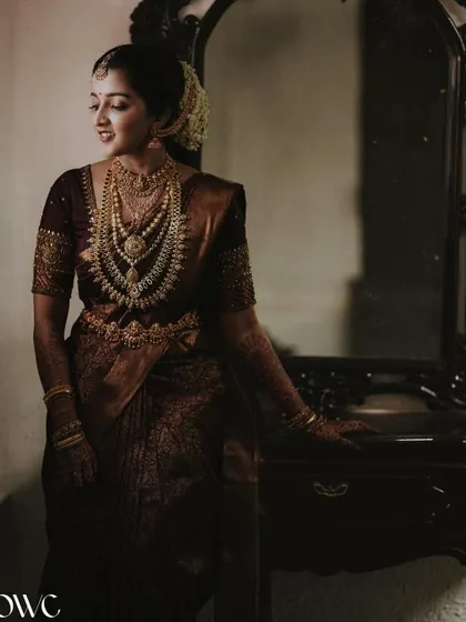 An elegant portrait of the bride by a mirror, her reflection adding depth to the image.