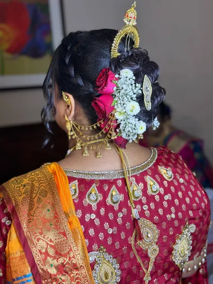 A beautiful bridal bun for a Maharashtrian ceremony, featuring an ambada hairstyle with fresh flowers and traditional hair jewelry.