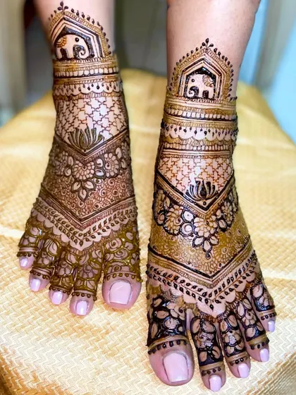 A lovely V-shaped foot design with elephant motifs at the top, surrounded by floral and net-like patterns.