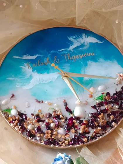 This beach-themed clock combines preserved flowers with the calming aesthetic of the ocean. The lower half is filled with preserved petals and shells, while the top half features a beautiful blue wave design.