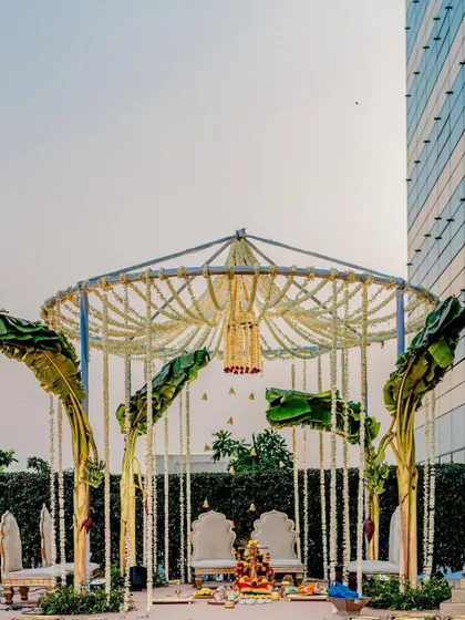 A minimal mandap design that proves simplicity can be stunning. We used fragrant mogra and rose garlands with fresh banana leaves to create a sacred, elegant space that complements the urban backdrop.