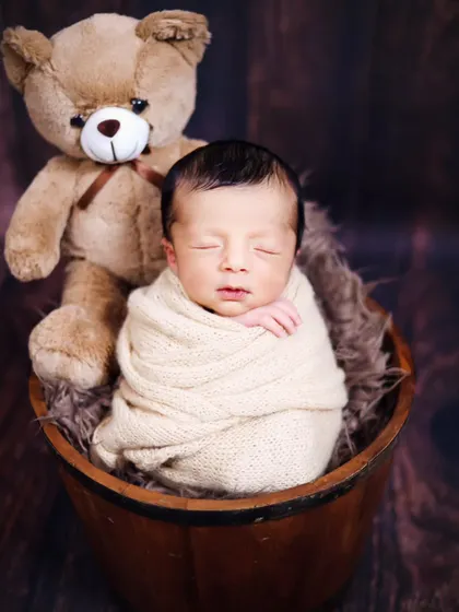 A sweet newborn portrait with a teddy bear companion. We have a variety of soft toys to include in your baby's first photoshoot.