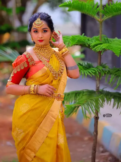 A beautiful outdoor shot of the yellow and red bridal saree, showing the rich colors in natural light.