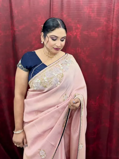 A beautiful soft glam look on a client wearing a delicate pink saree. The makeup is understated and elegant, perfect for a daytime event.