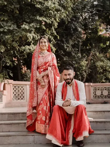 A relaxed portrait of the couple on steps, showcasing their traditional outfits and the easy chemistry between them.